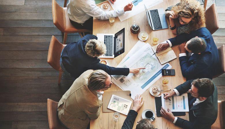 A photo from above a conference table where people are working together.