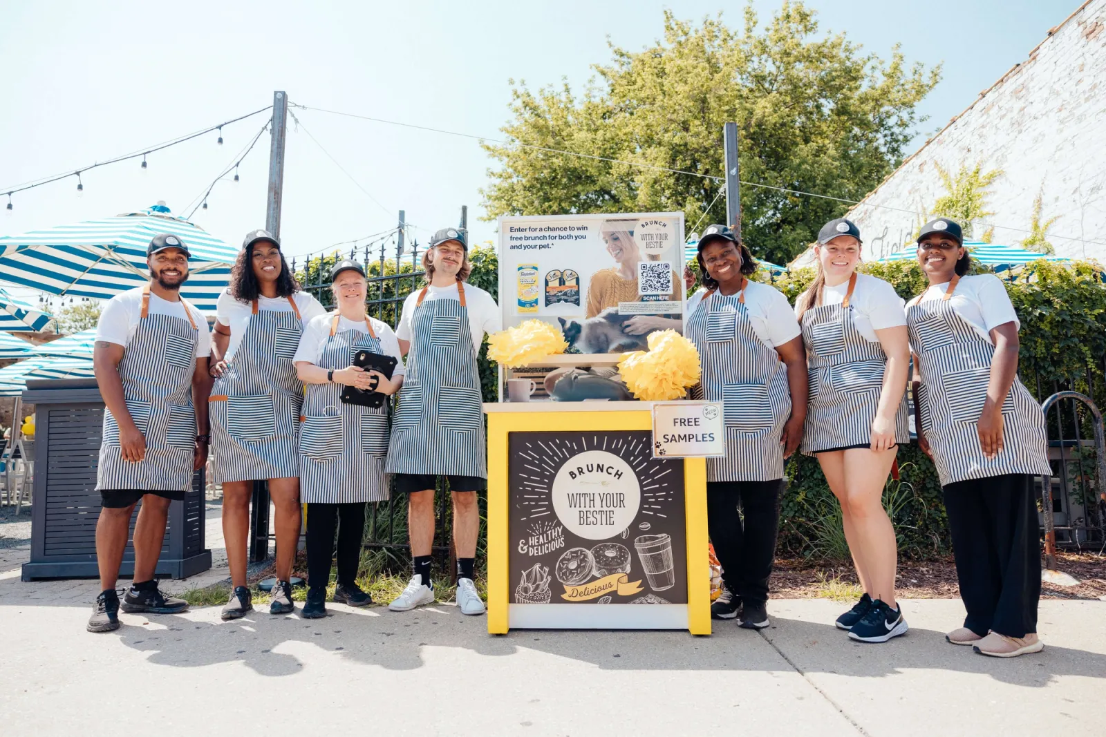Image of brand ambassadors staffing a brunch sampling booth at an outdoor experiential marketing event