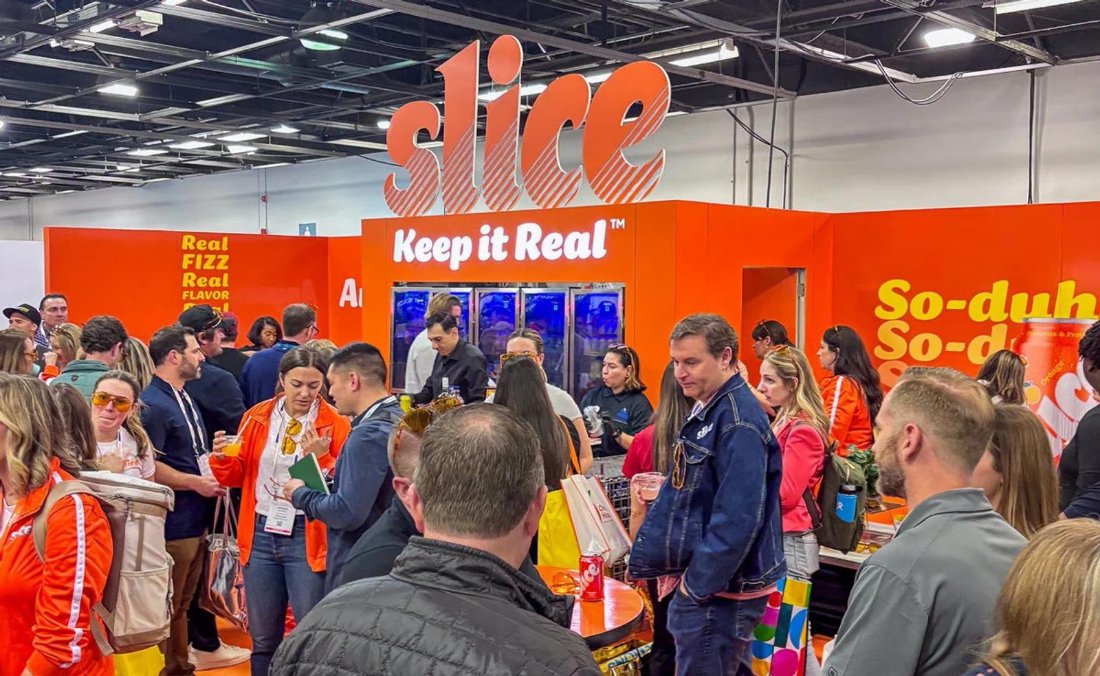 Experiential marketing tactics in action with Slice booth drawing a large engaged crowd