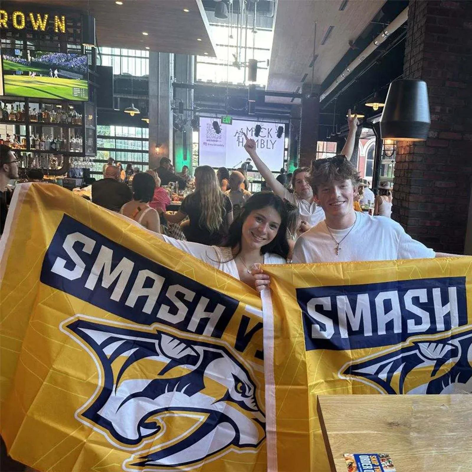 Image of Nashville Predators fans holding Smash flags at a sports bar during a hockey watch party