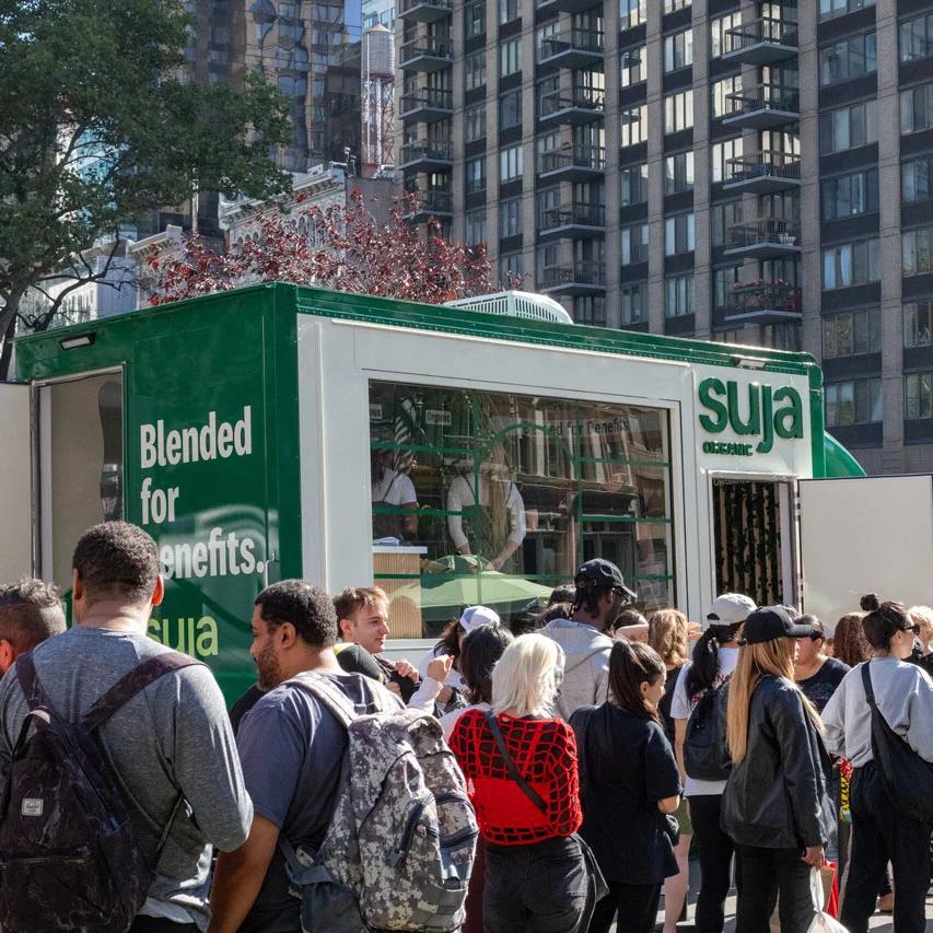 Image of a crowd gathered outside the Suja Organic pop-up booth in a city street