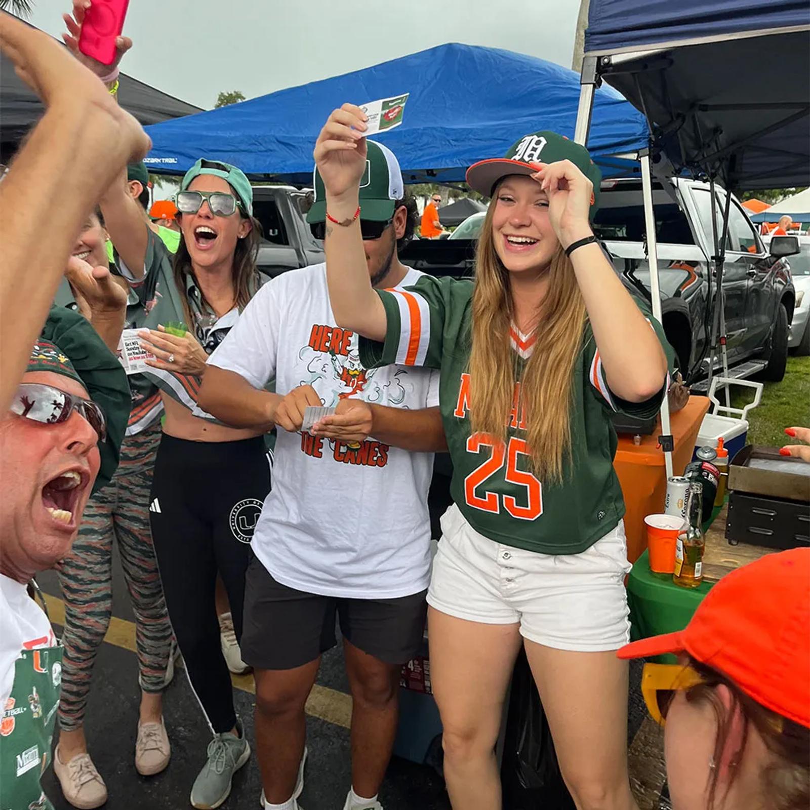Image of University of Miami fans at a tailgate cheering with YouTube NFL Sunday Ticket offer cards
