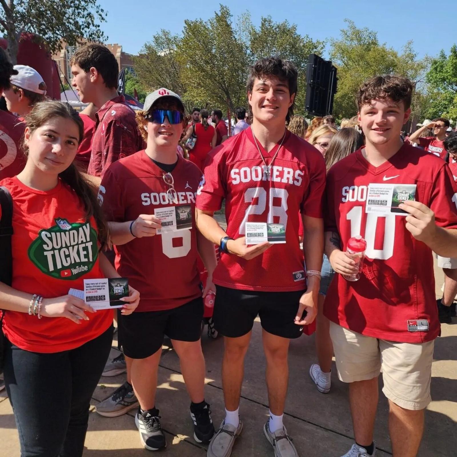 Image of University of Oklahoma students holding YouTube NFL Sunday Ticket student offer cards on game day