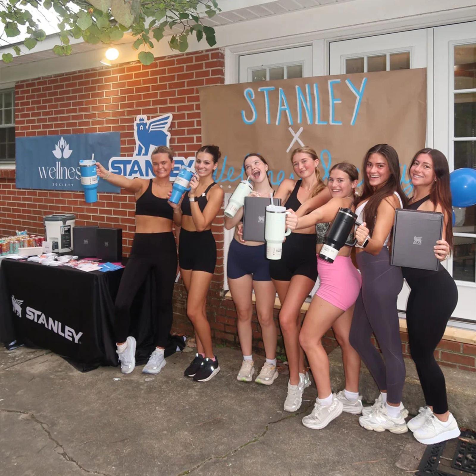 Image of college women holding Stanley tumblers at a Stanley x Wellness Society campus brand activation