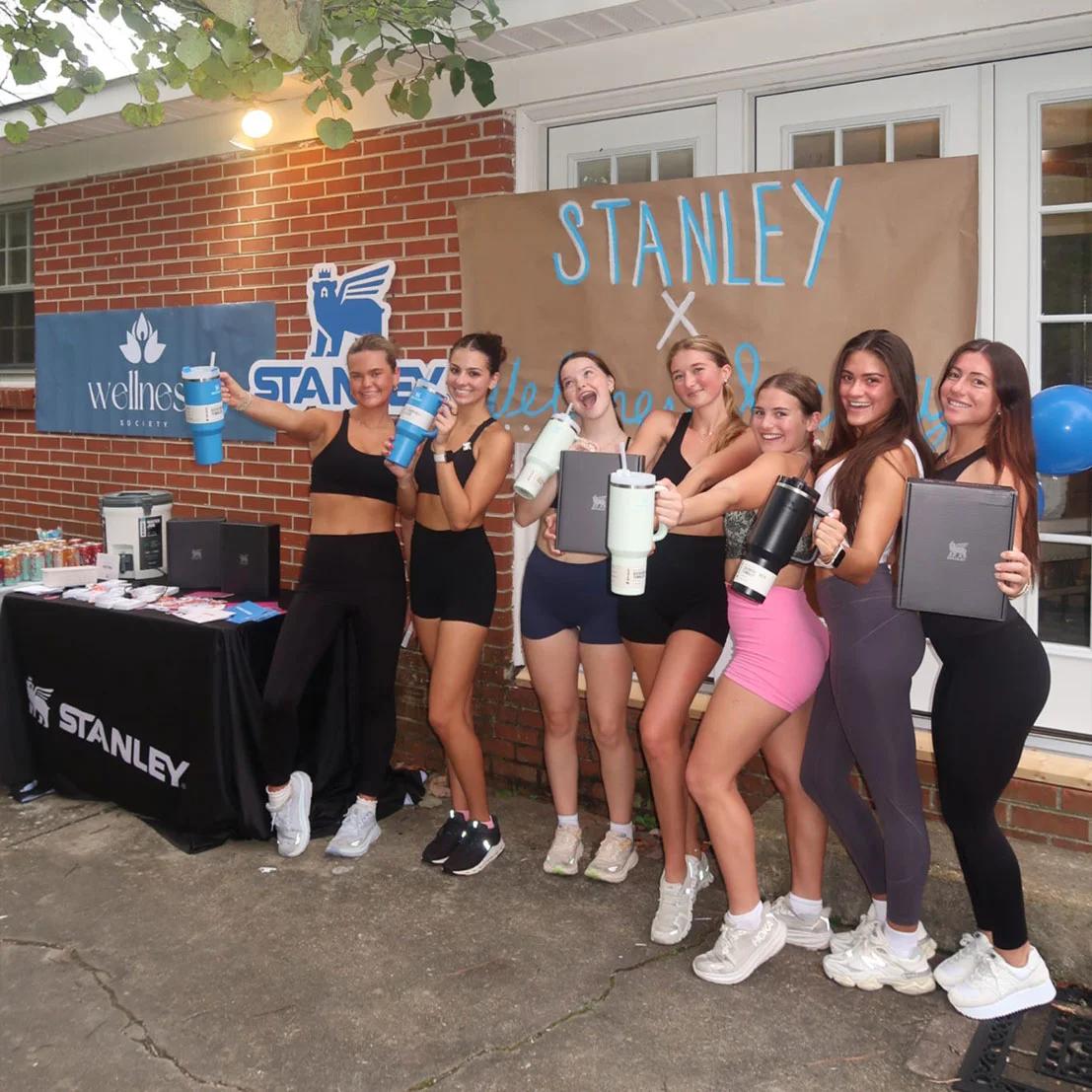 Image of college women holding Stanley tumblers at a Stanley x Wellness Society campus brand activation