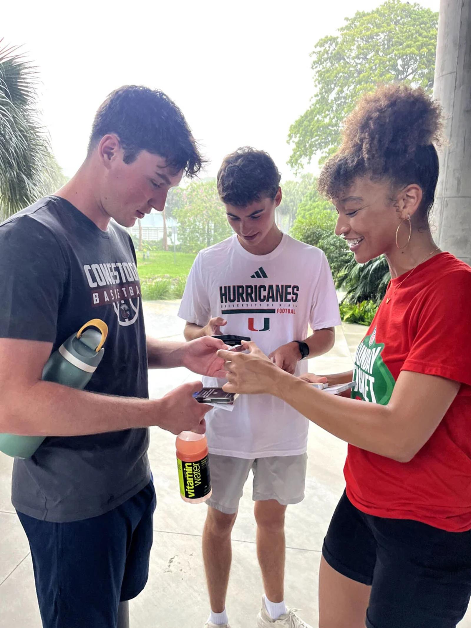 Photo three people exchanging items showing how to engage gen z with live experiences