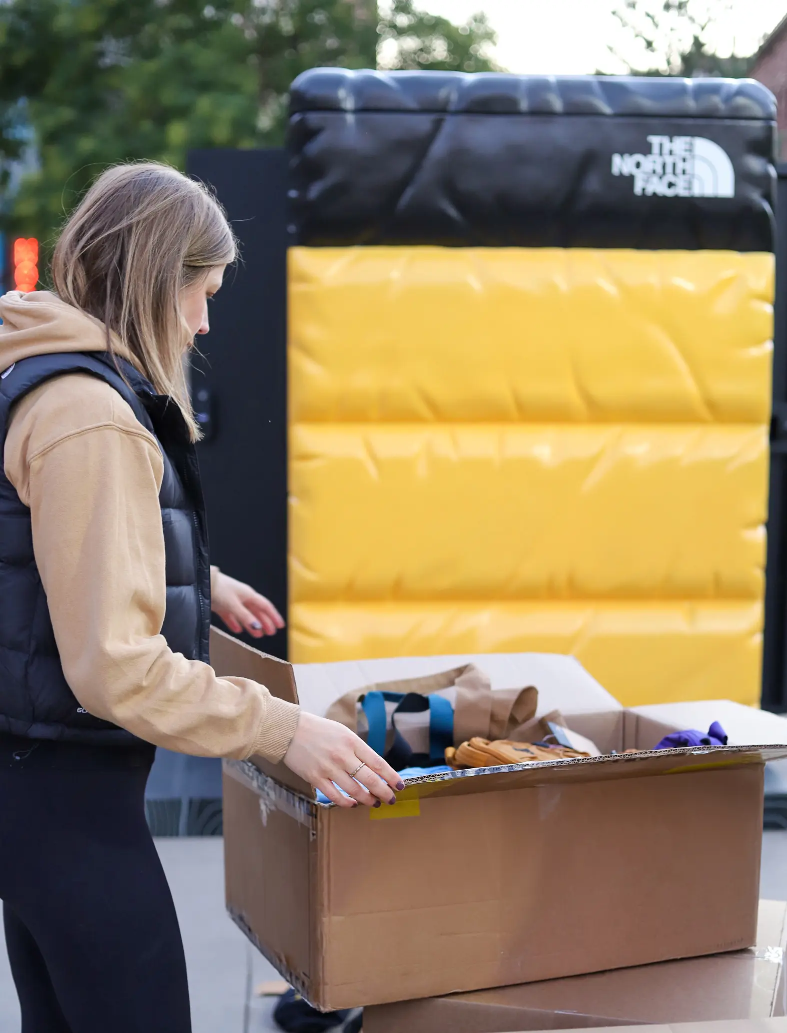 Newbridge worker organizing box of supplies for the event. The North Face locker is in the background.
