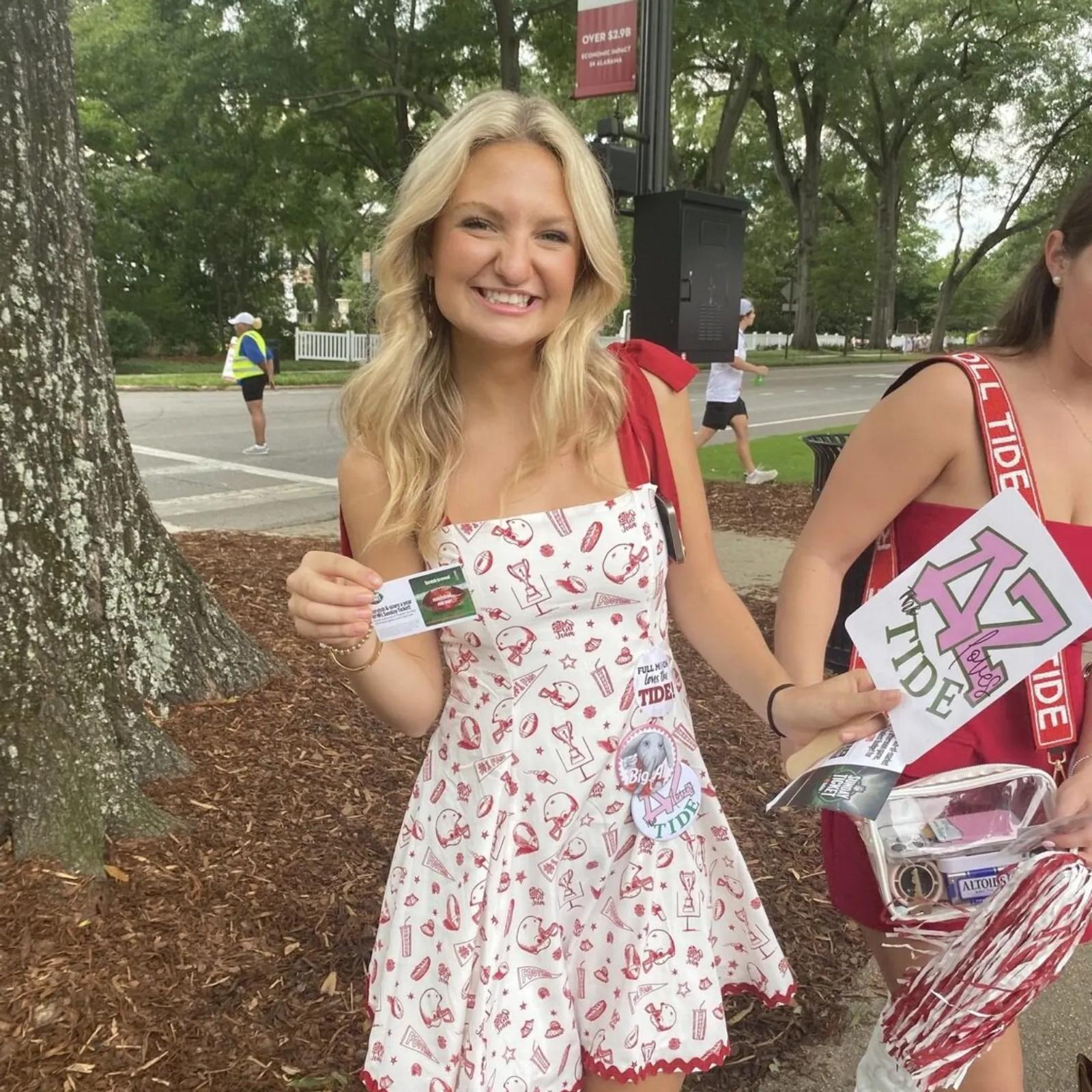 Image of a University of Alabama student holding a YouTube NFL Sunday Ticket scratch card on game day