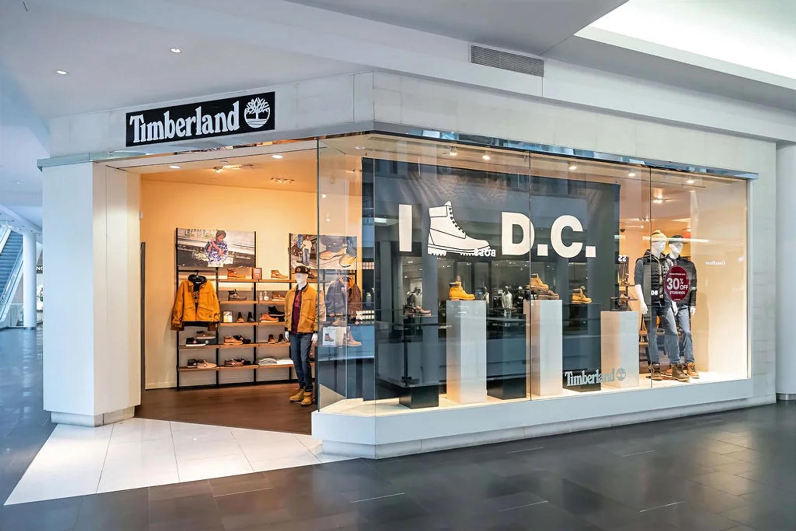 Image of a shopper photographing the Timberland Icons heritage boot wall display in a Timberland retail location