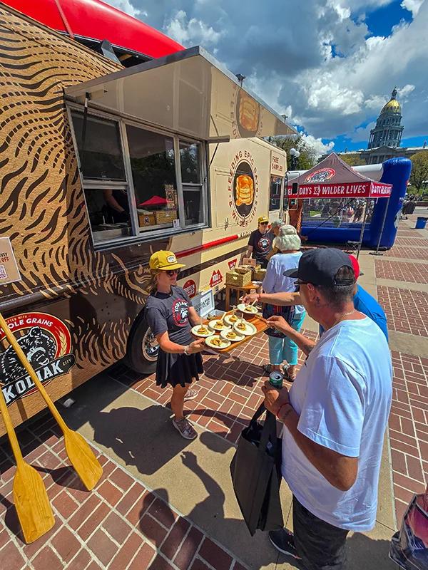 People enjoying Kodiak Cakes samples outdoors at the Kodiak food truck