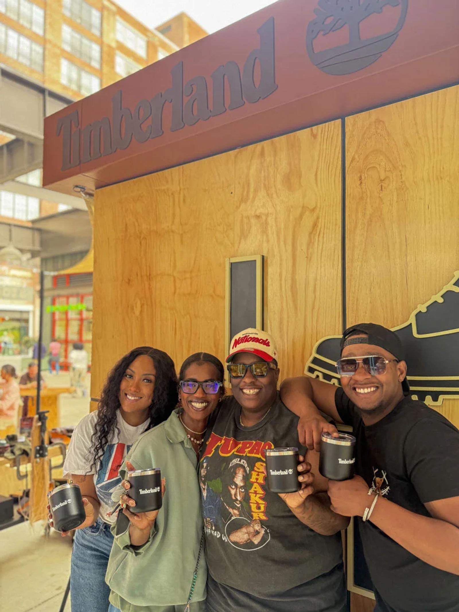 Image of four people holding Timberland tumblers at an outdoor brand activation event