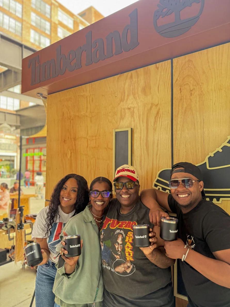 Image of four people holding Timberland tumblers at an outdoor brand activation event