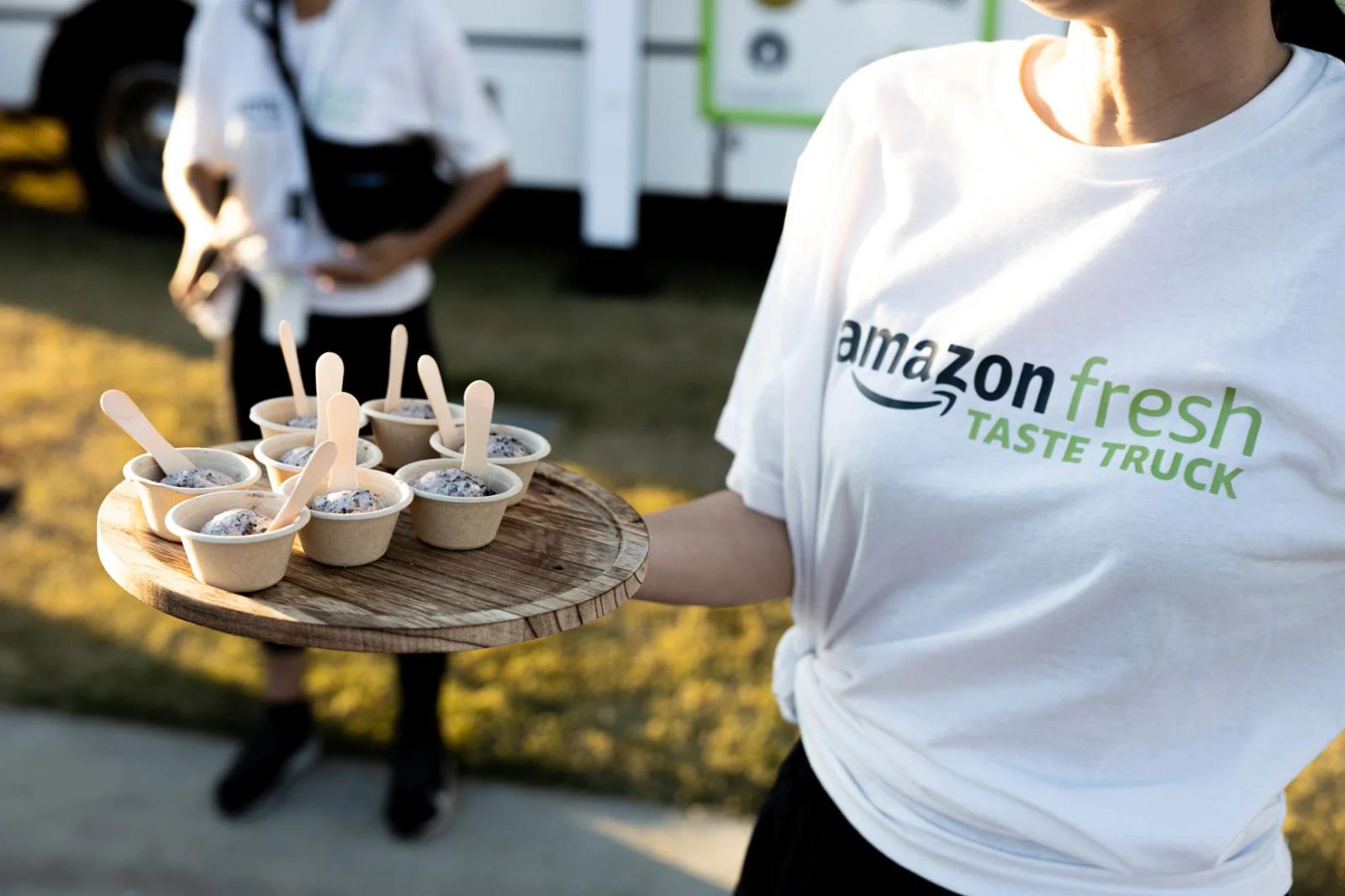 Image of an Amazon Fresh Taste Truck brand ambassador serving ice cream samples at a CPG sampling event