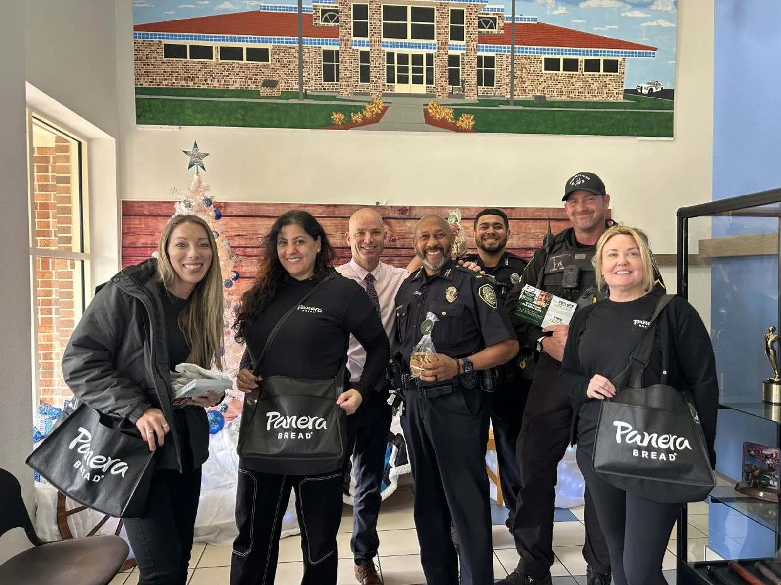 Image of Panera Bread ambassadors delivering treats to police officers during a holiday visit