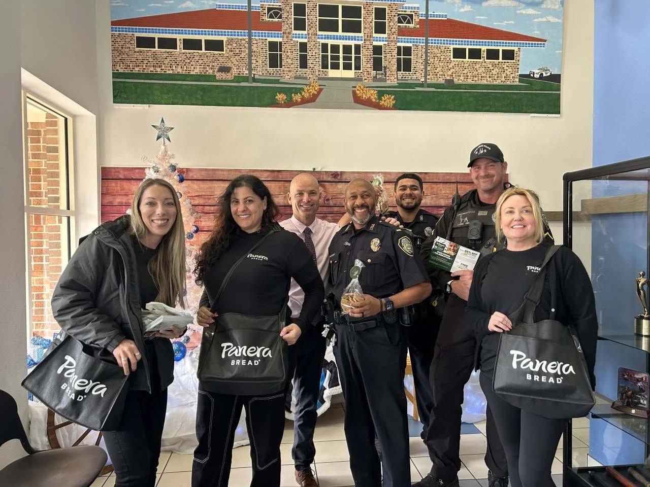 Image of Panera Bread ambassadors delivering treats to police officers during a holiday visit