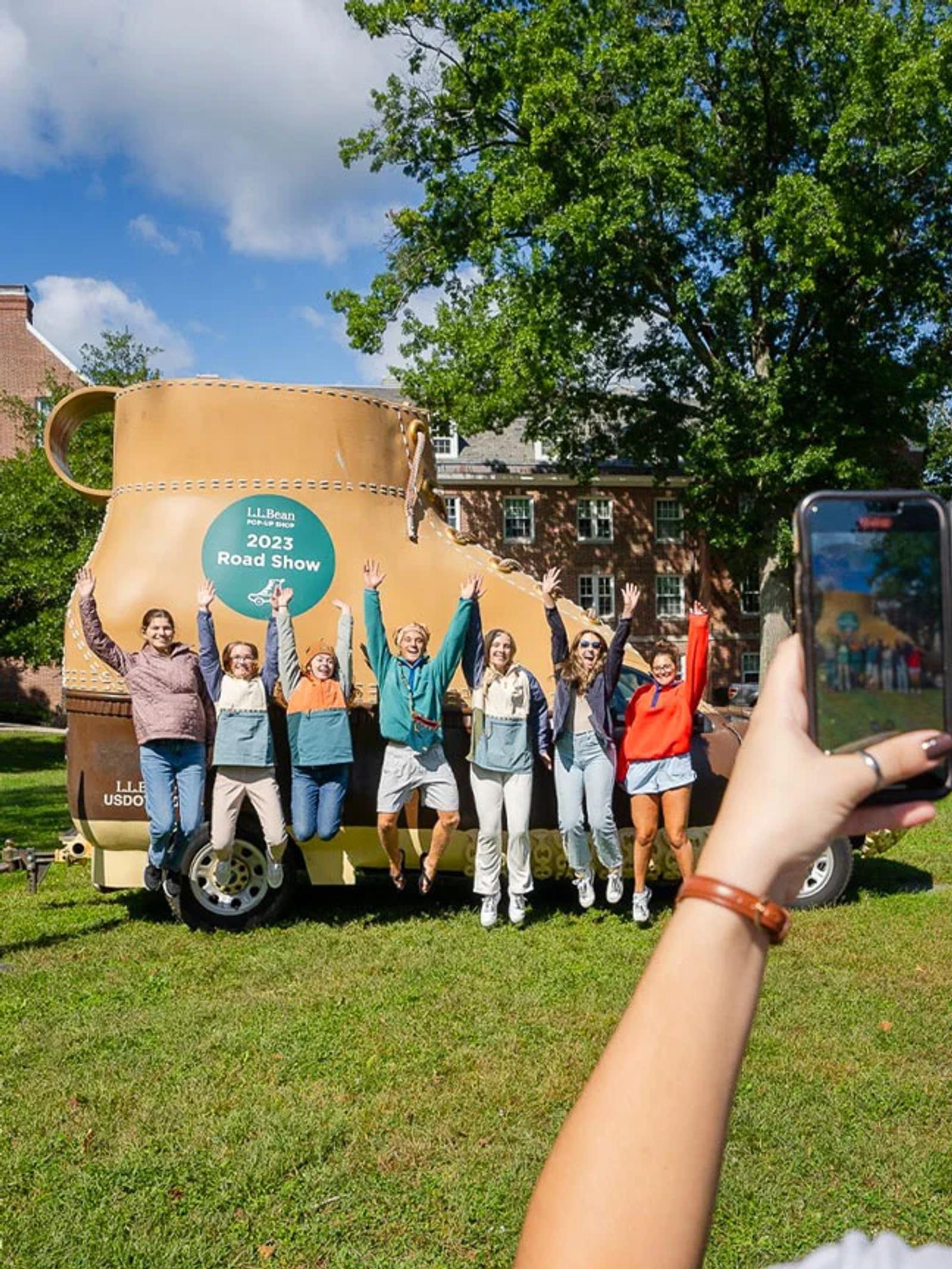 Image of attendees posing beside the L.L.Bean Road Show experiential activation on a college campus