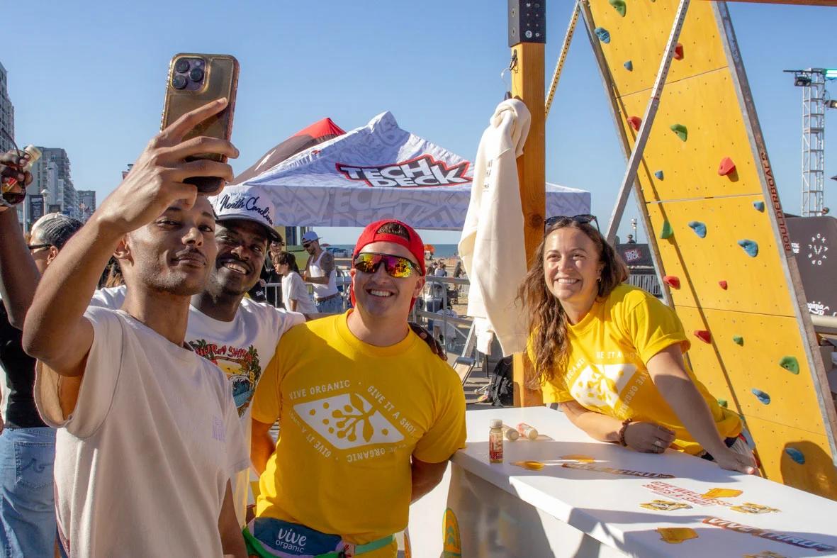 Image of attendees taking a selfie with brand ambassadors at a beachside product activation