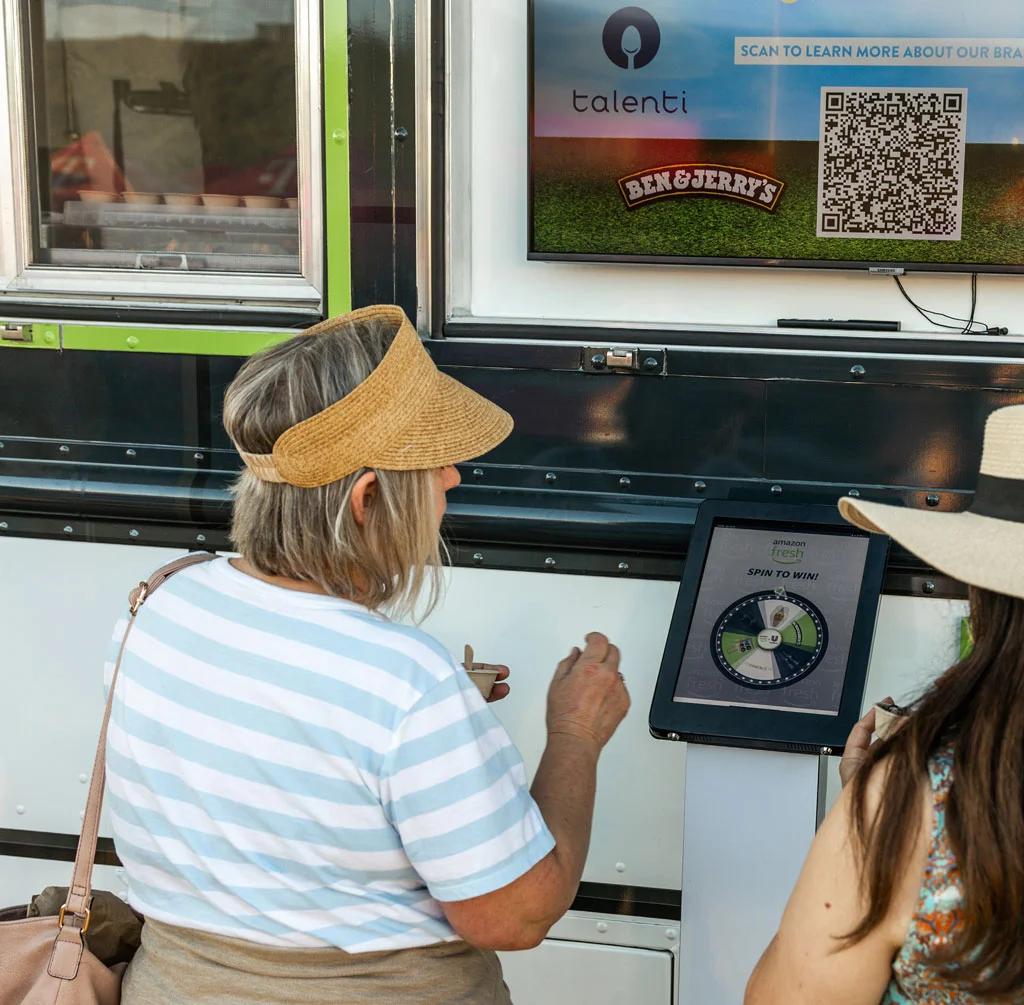 Image of attendees using a spin-to-win kiosk at an ice cream experiential marketing truck