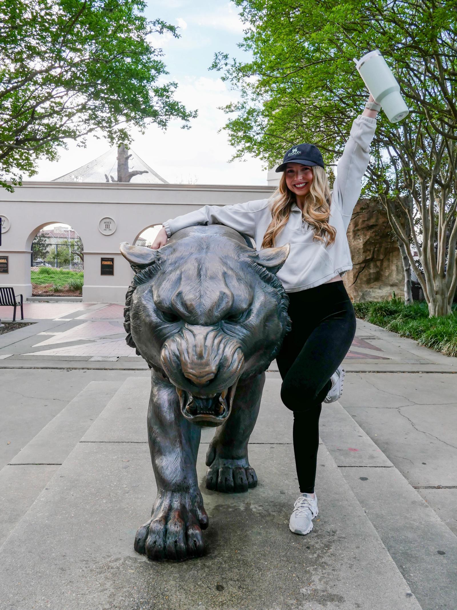Student posing with mascot holding a Stanley 
