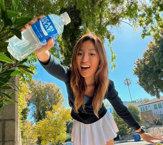 Girl holding water bottle at a marketing pop up