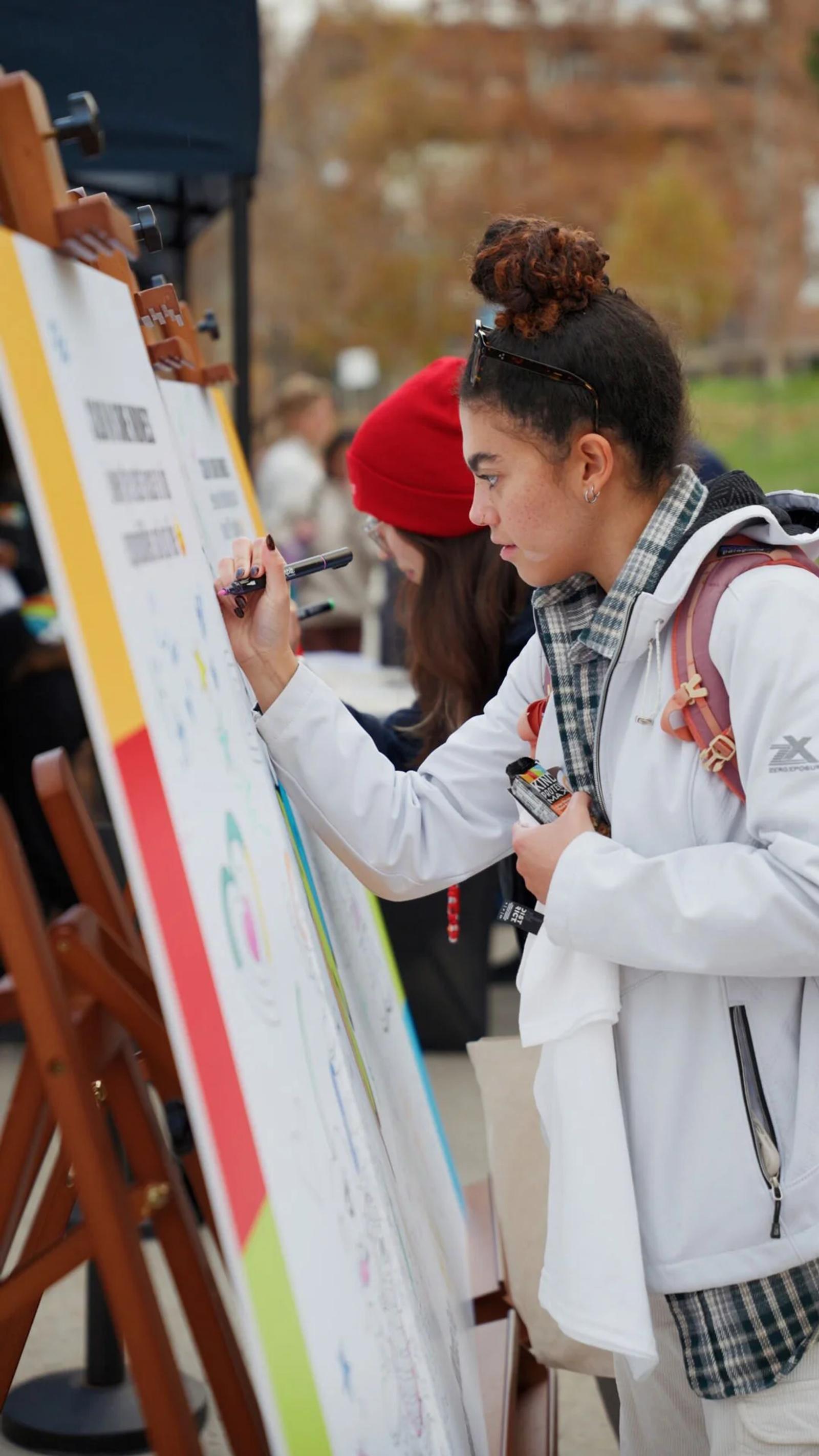 Photo person writing on display board at outdoor event