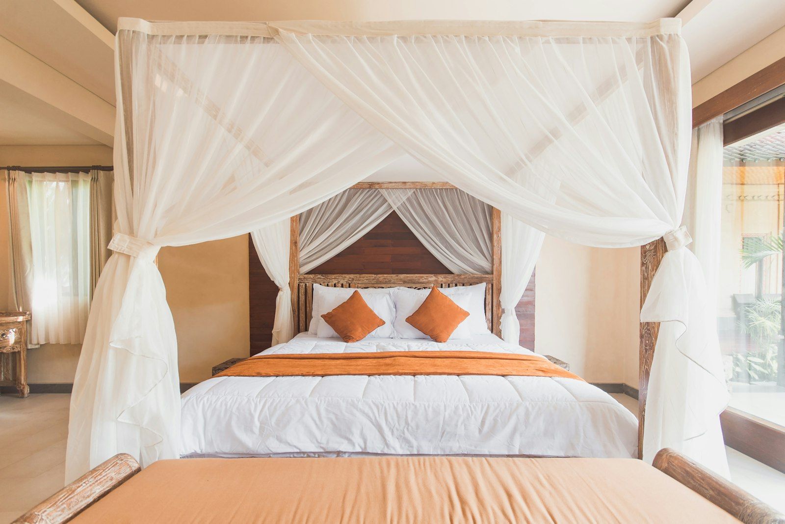 A mosquito net draped over a bed, one way to keep mosquitoes off while you sleep