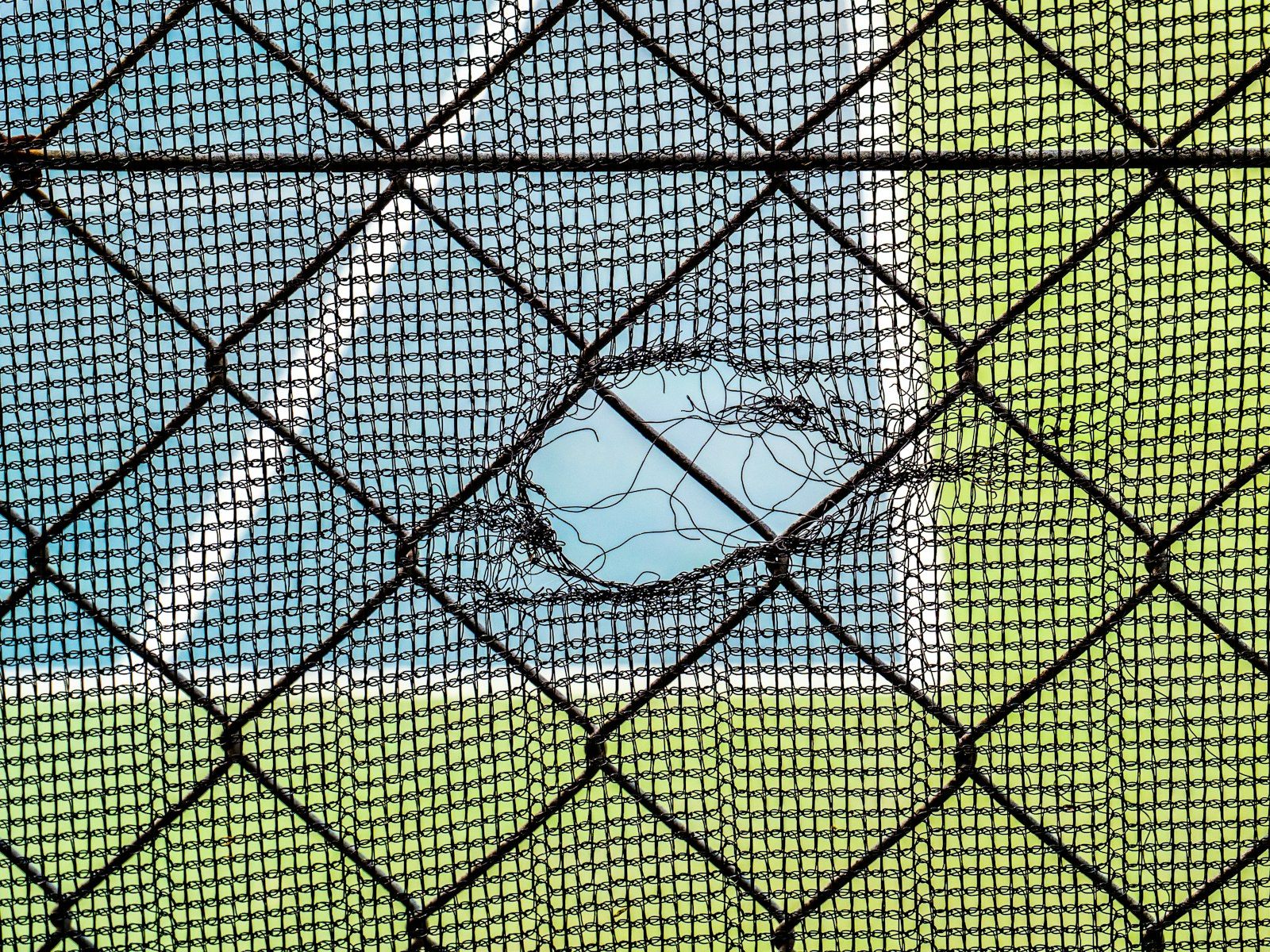 Torn netting with blue and green background