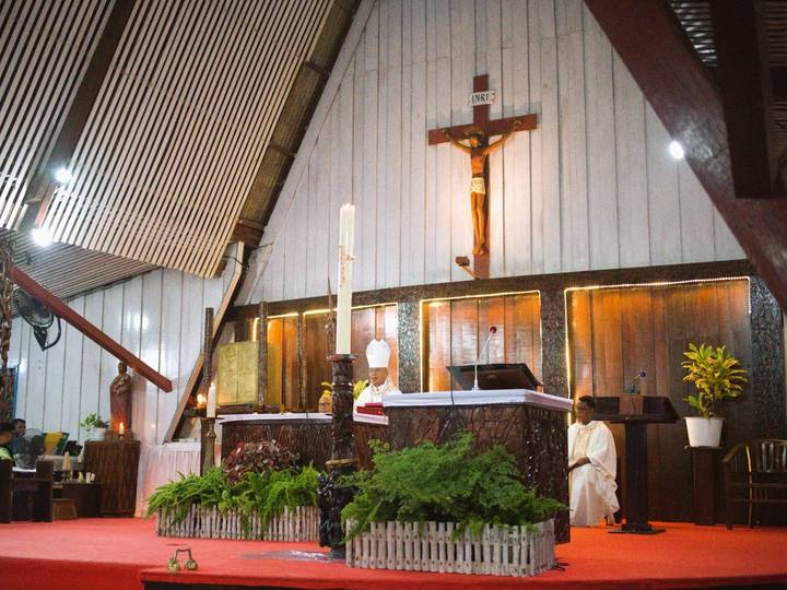 Perayaan Ekaristi di Katedral Salib Suci: salib, lilin, dan altar berukir, imam di mimbar.