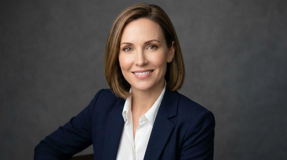 Professional woman with relaxed smooth features in a headshot.