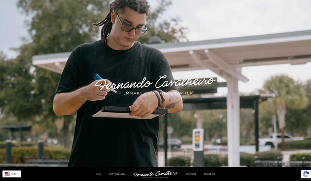 Fernando escrevendo numa claquete, em um estacionamento, com a logo "Fernando Cavalheiro, filmmaker & photographer" sobre a foto.