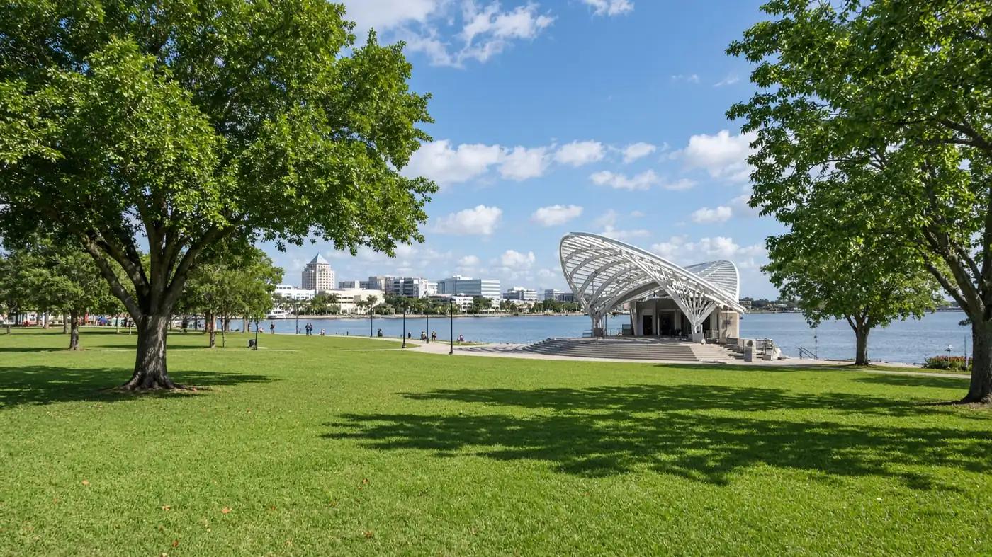 Downtown Clearwater waterfront park with a green lawn, shade trees, and the bay on a sunny afternoon