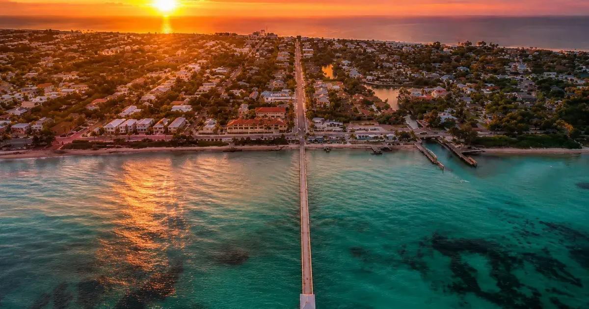 Aerial sunset over Anna Maria Island pier and Gulf water for a short-term rental market guide