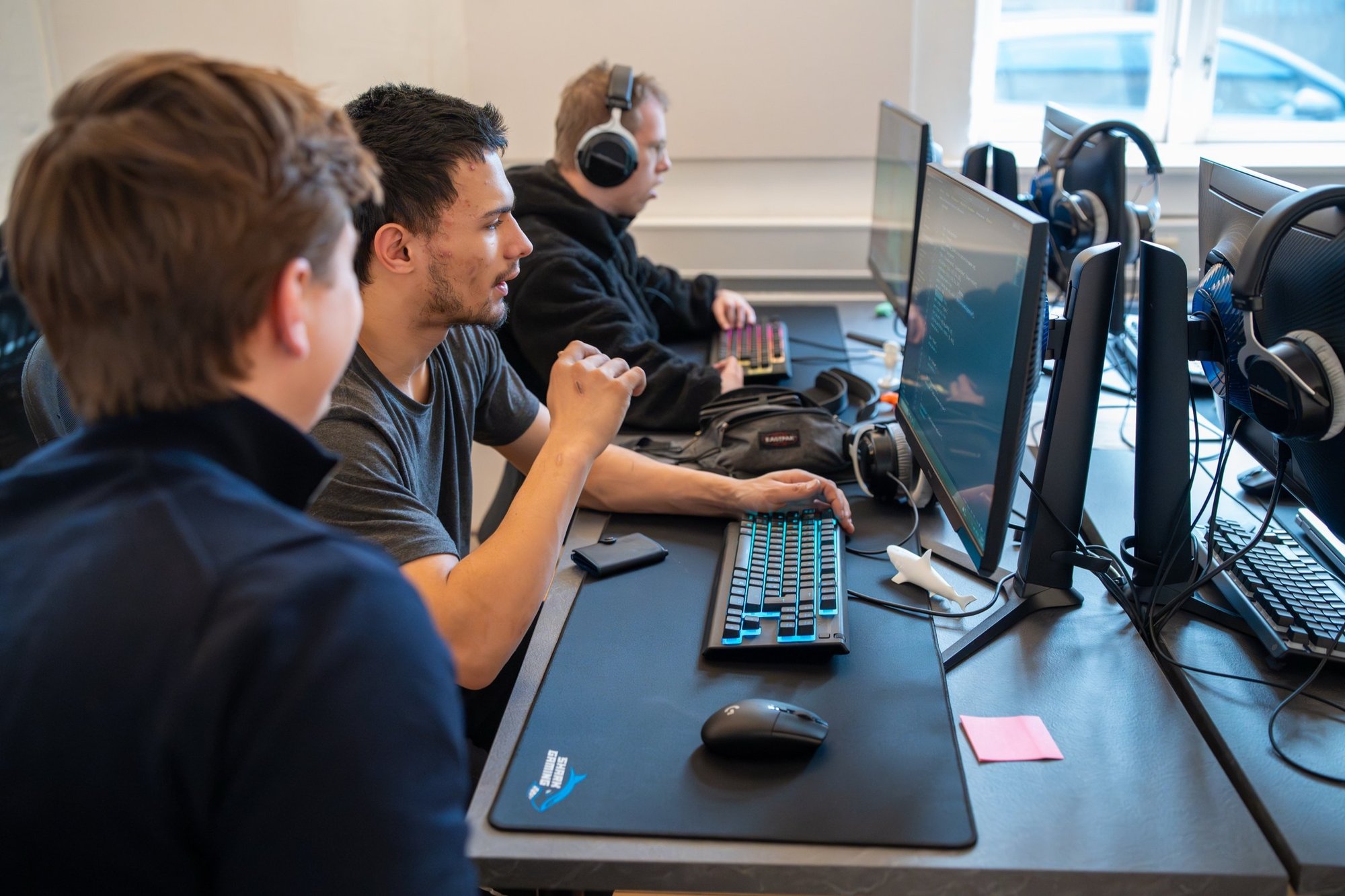 Tre STU-elever arbejder ved hver sin computer hos Socialcode