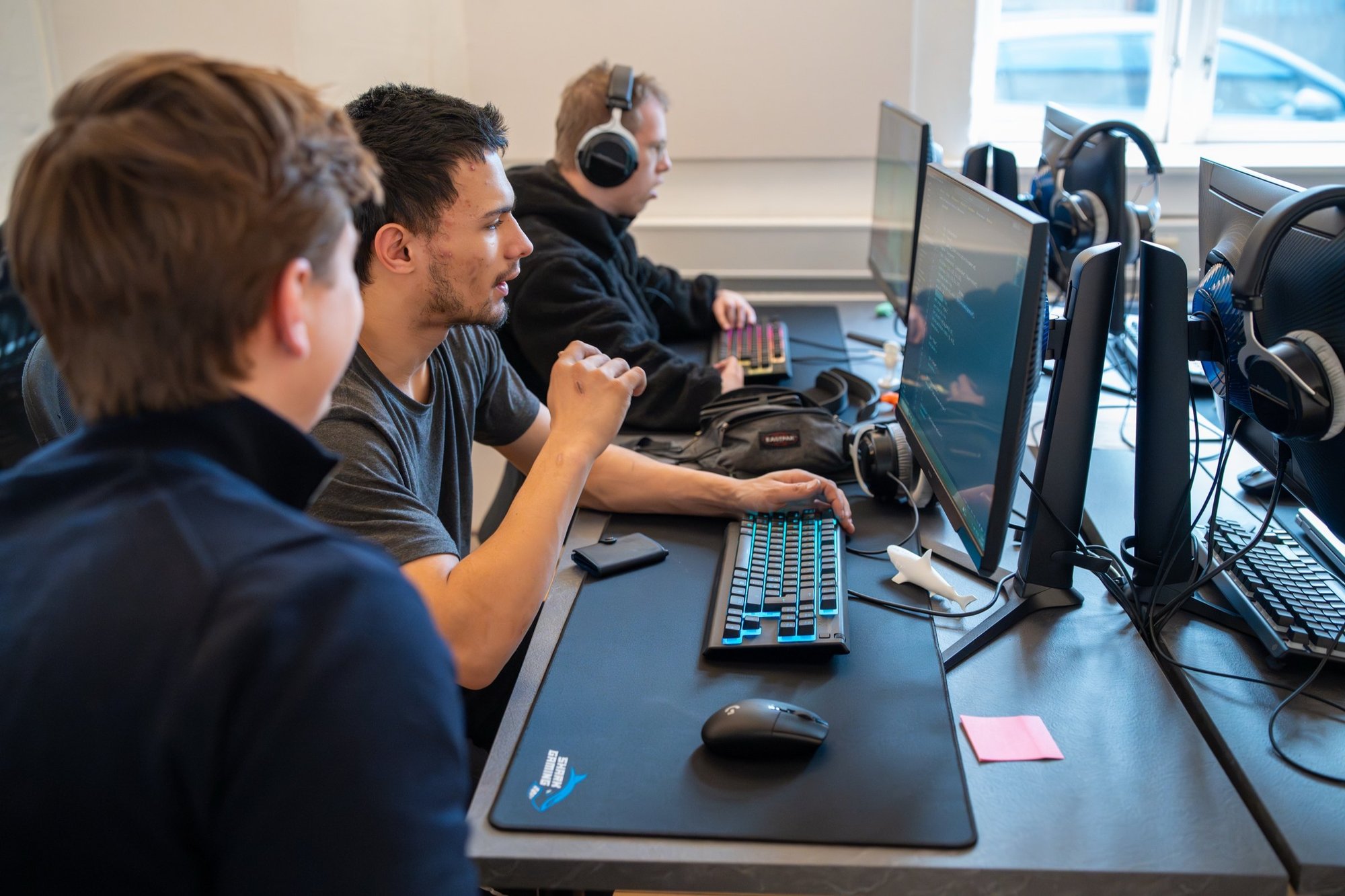 Tre STU-elever arbejder ved hver sin computer hos Socialcode