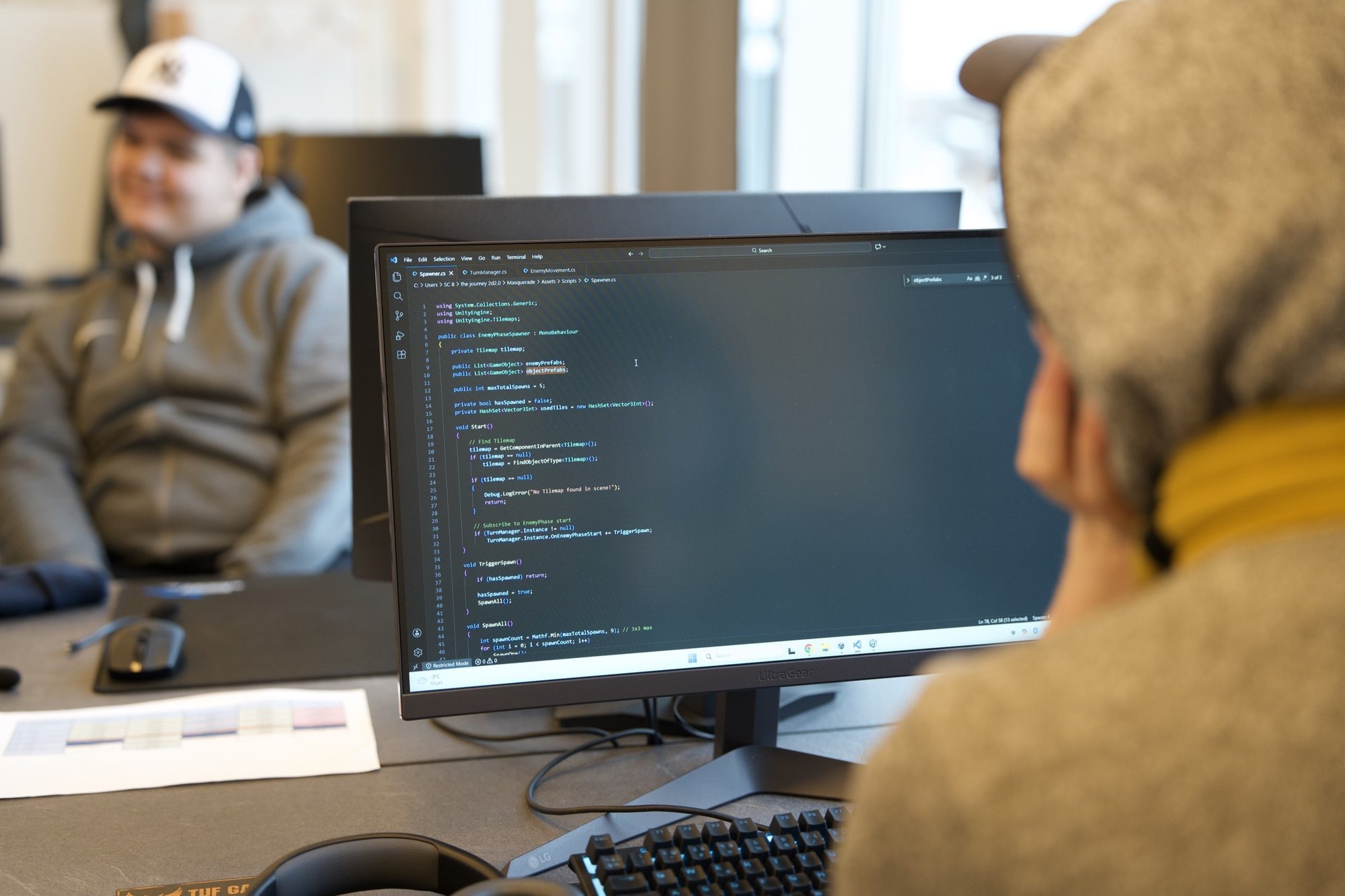 Smilende elev ved en skærm med kode hos Socialcode STU