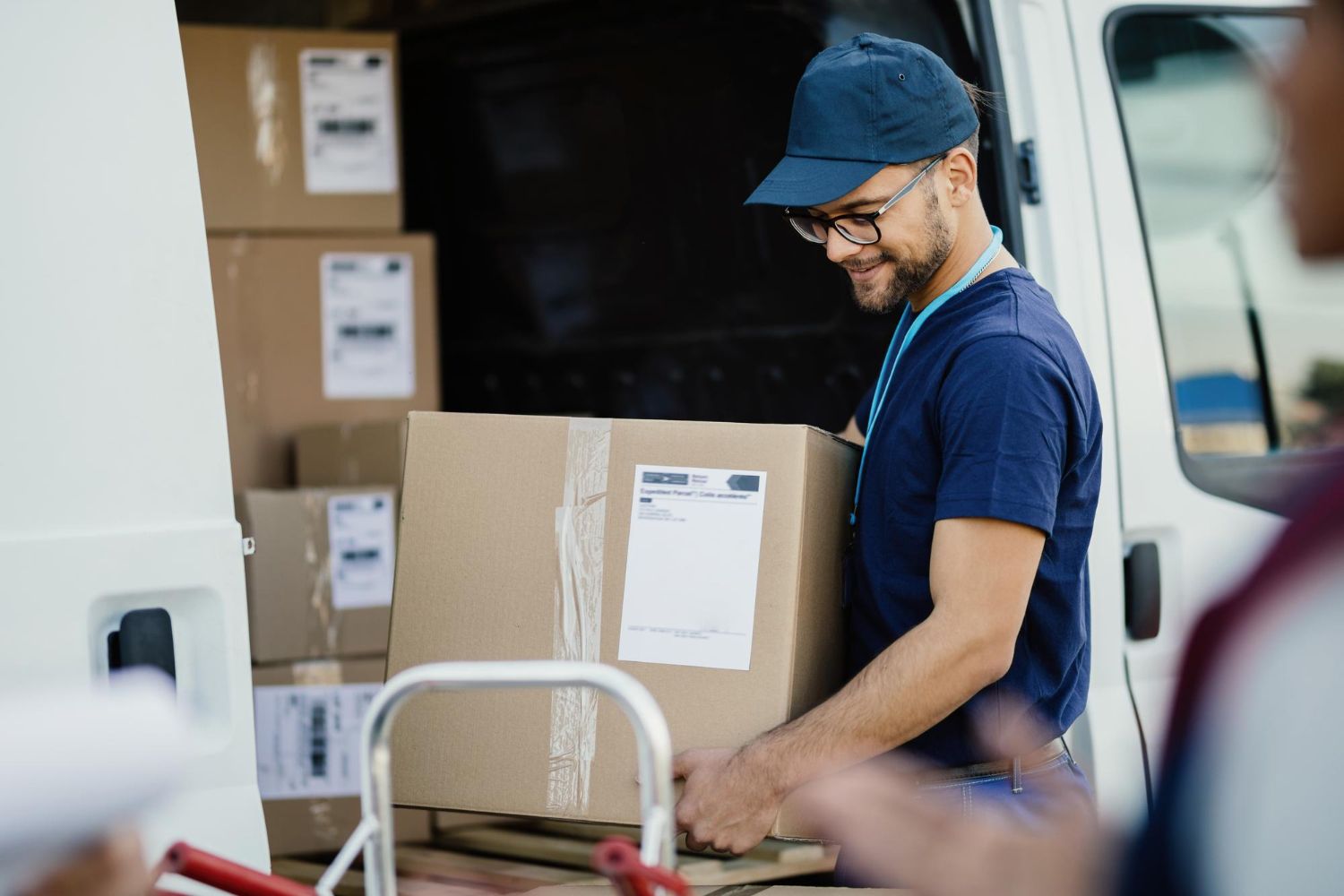 Courier driver loading parcels into a delivery van