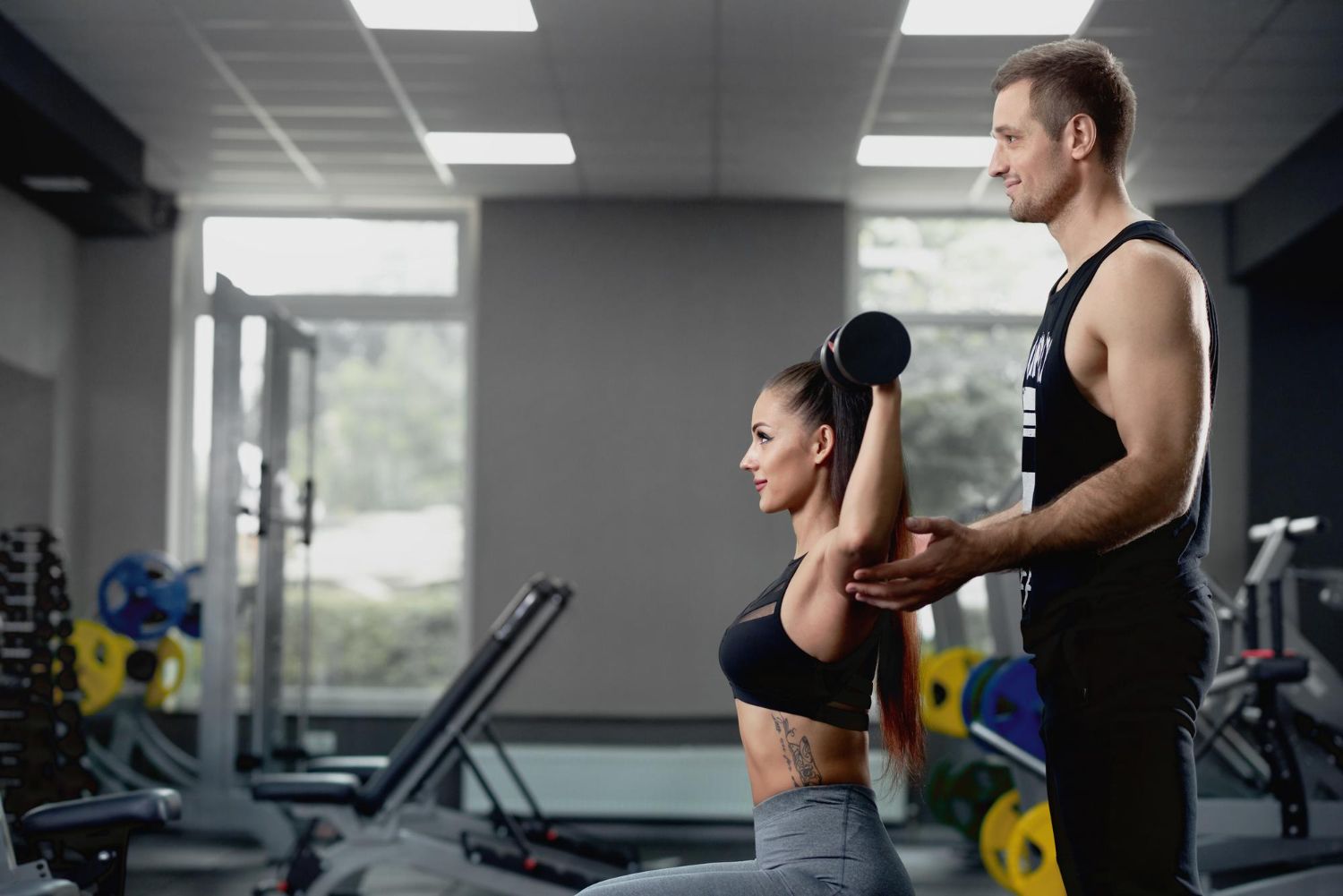 Personal trainer coaching a client through a workout in a gym