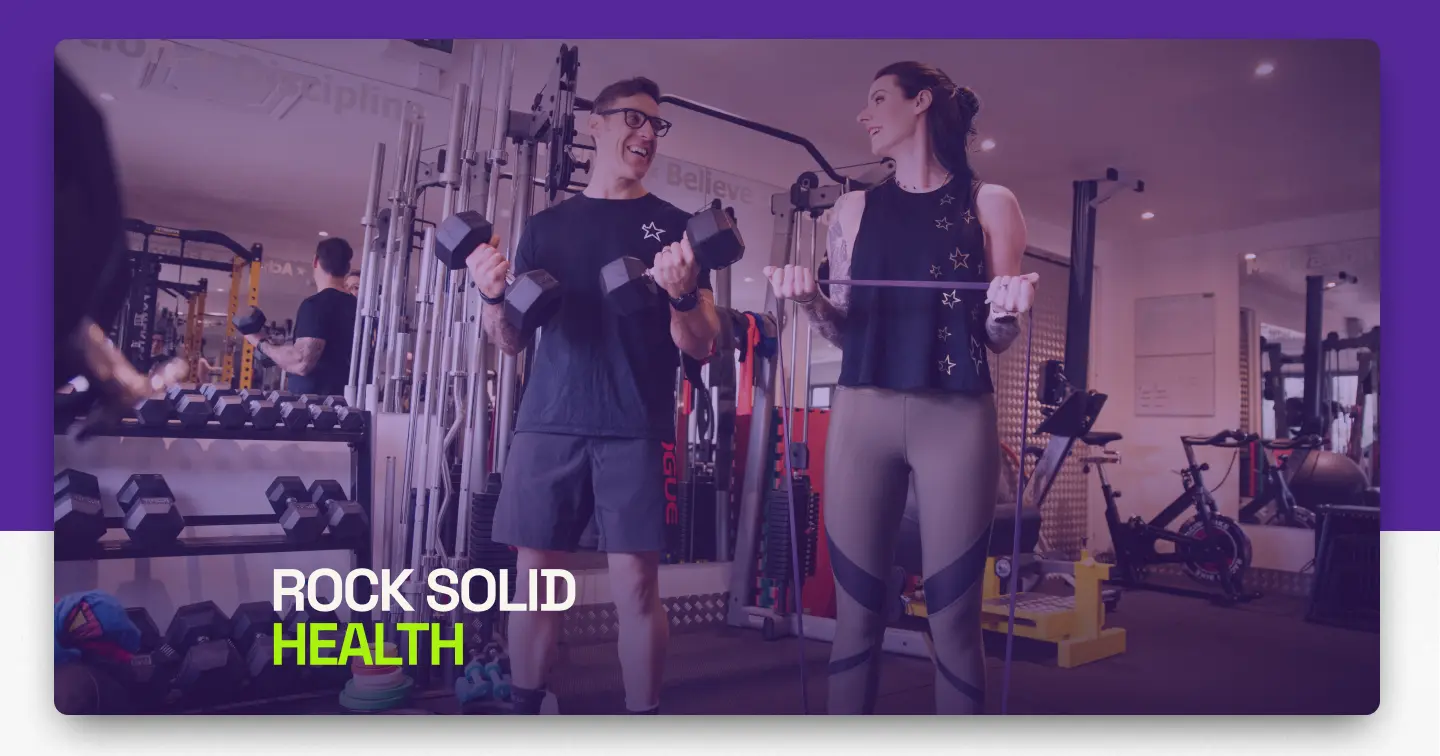 Two people training with dumbbells in the gym, under the Rock Solid Health wordmark