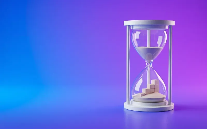 An hourglass with the fallen sand forming a rising staircase, representing how long SEO takes to work