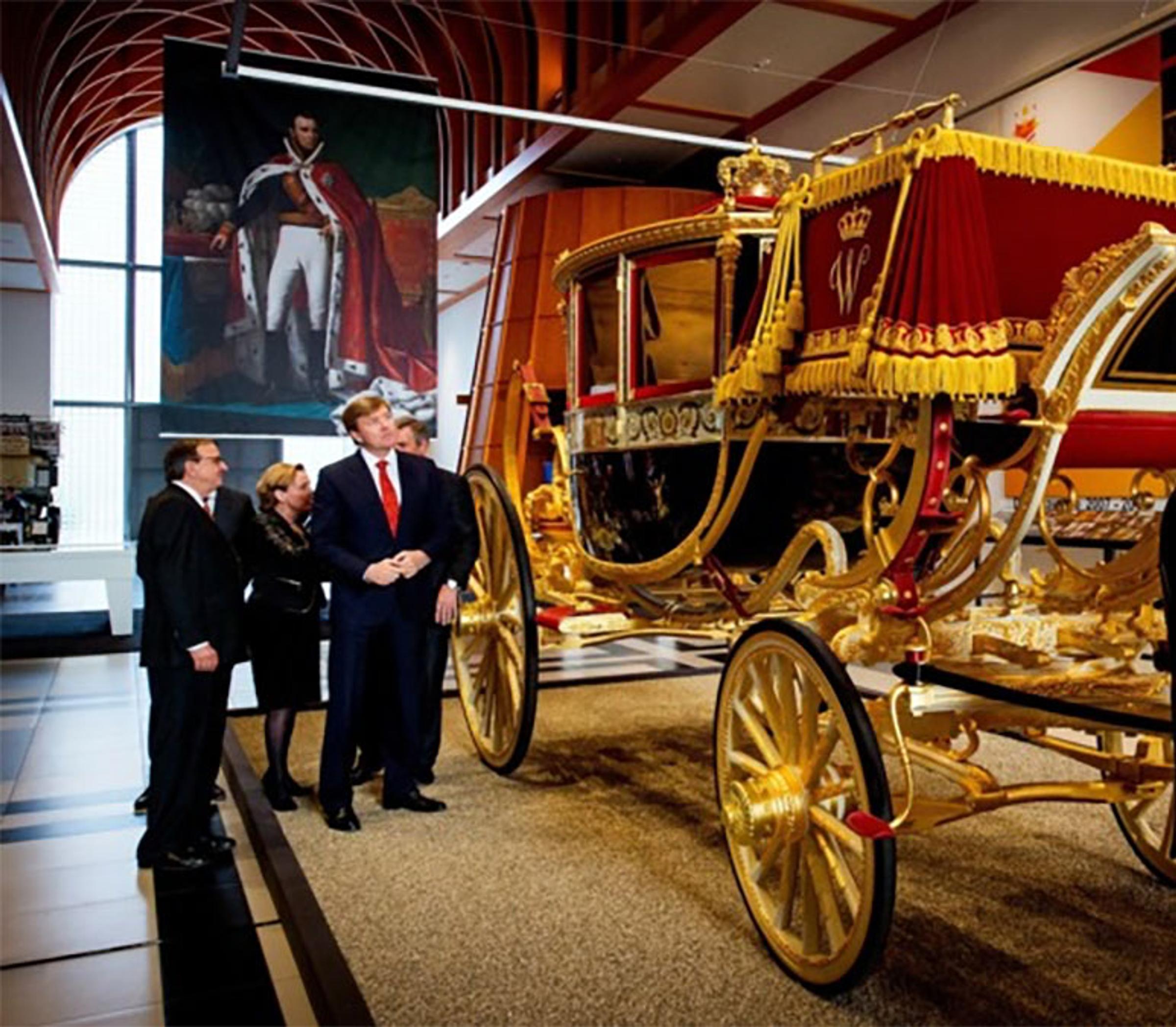Evert Louwman met de koning prins willem alexander bij de gouden koets in het Louwman museum