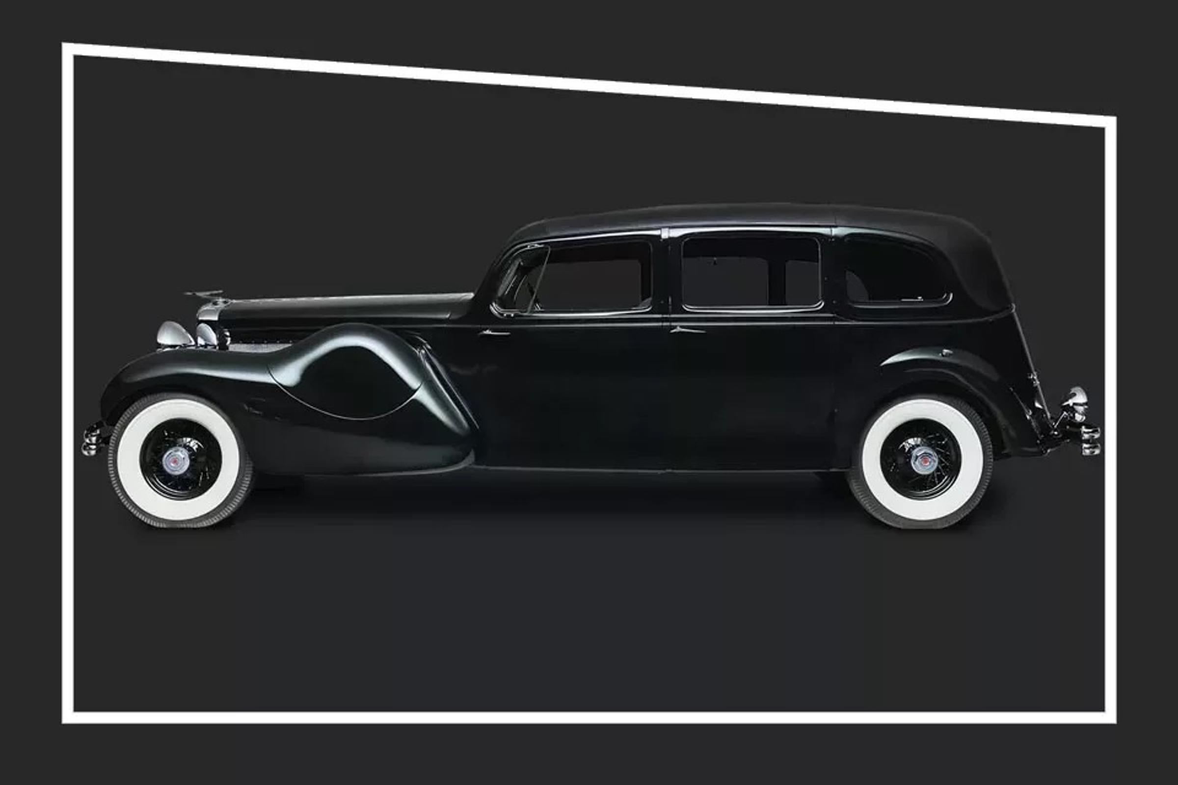 Black car with white tires from the side in black studio