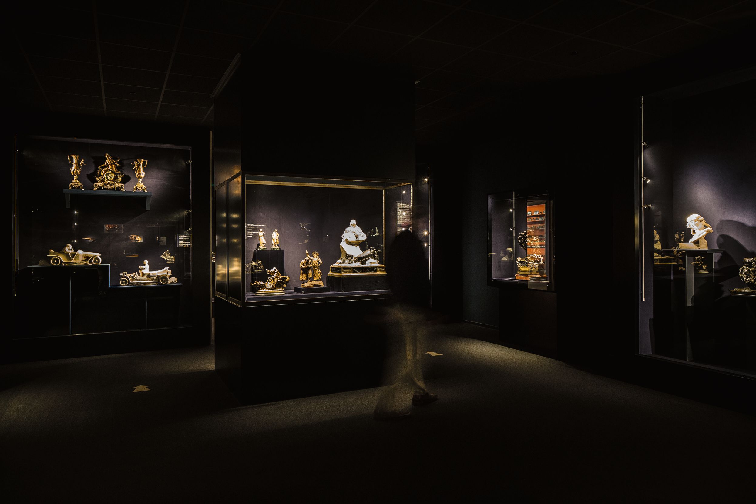 Donkere kunstzaal met autogerelateerde objecten