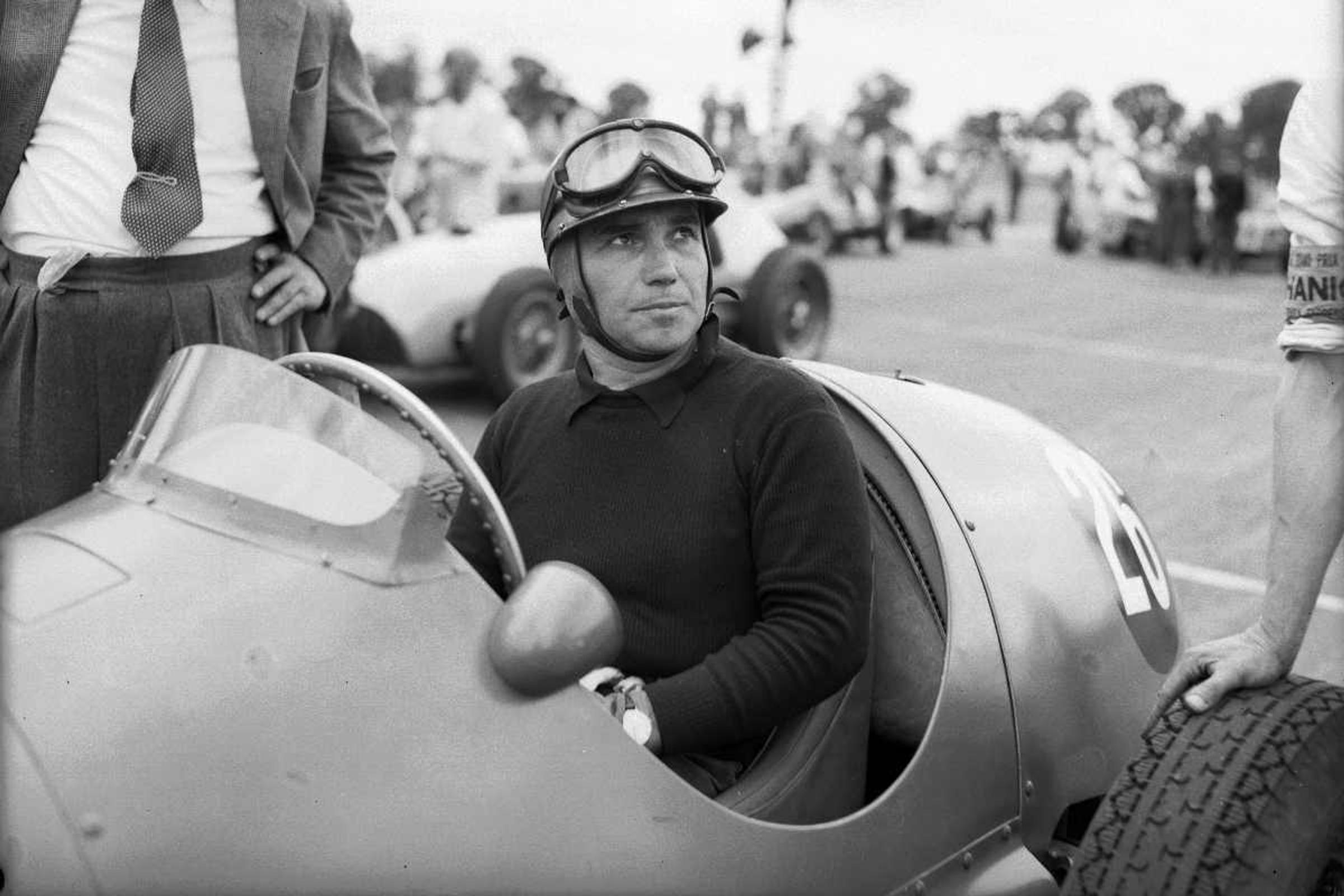 Coureur in raceauto met helm kijkt omhoog