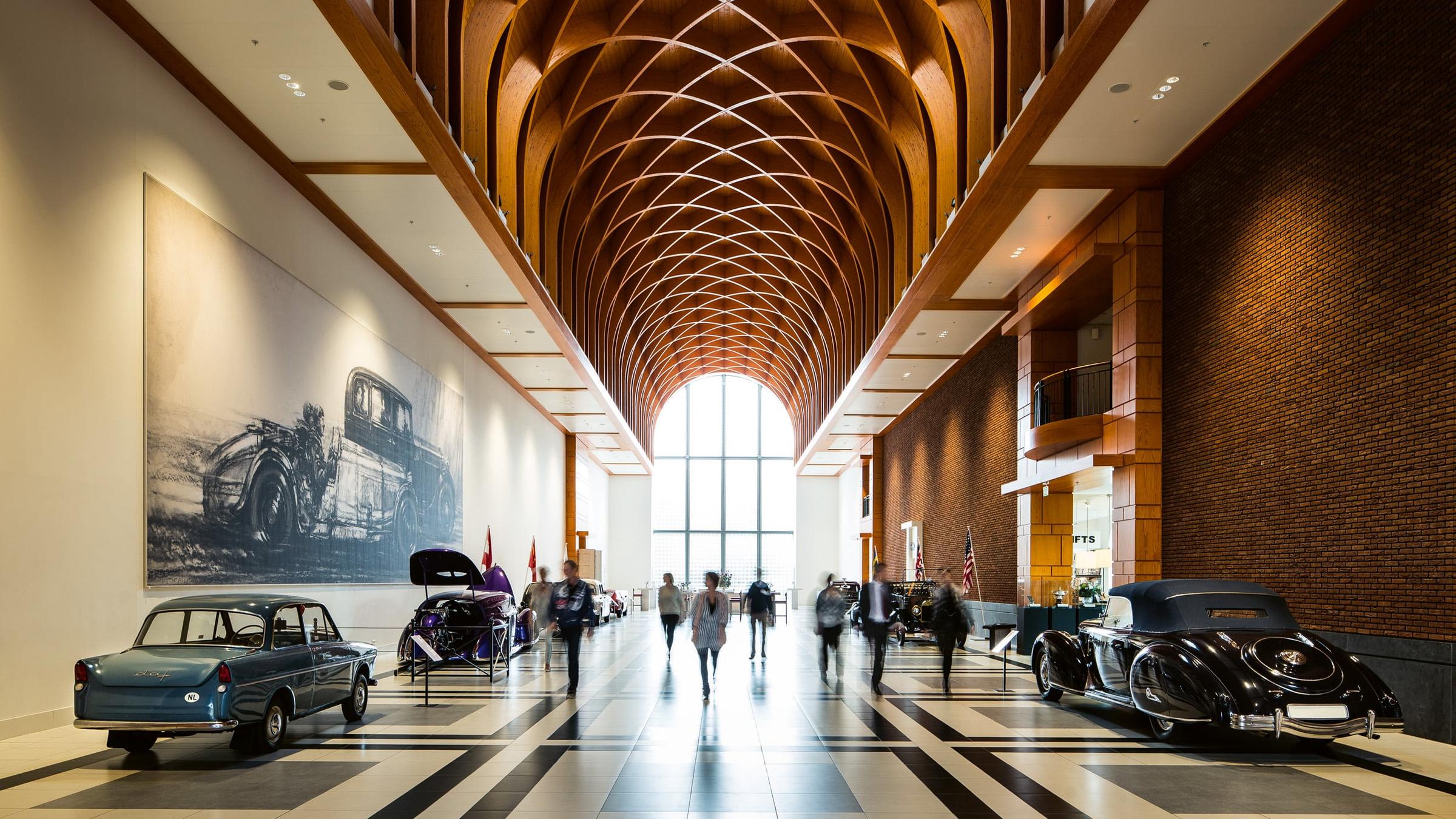 Familie die de McLaren bewondert tijdens een bezoek in Het Louwman Museum vanaf de buitenkant