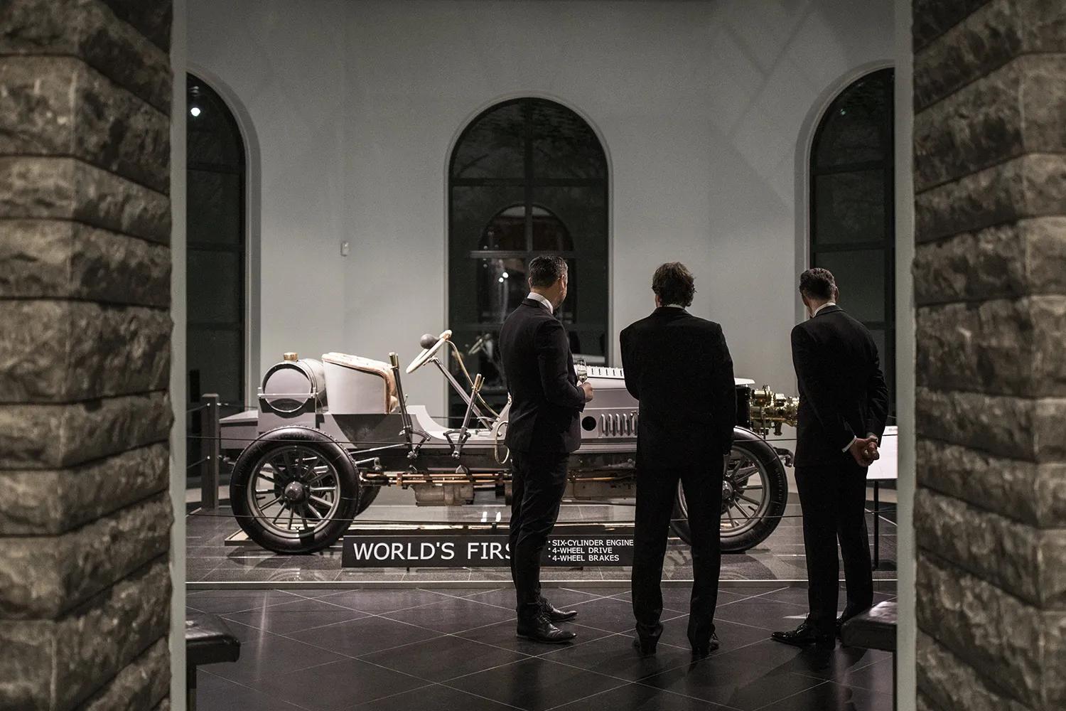 Drie mannen in pak voor de eerste auto ter wereld