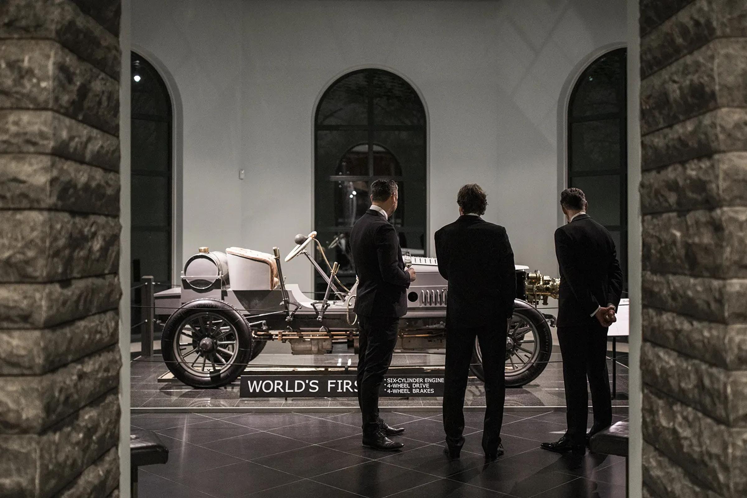 Drie mannen in pak voor de eerste auto ter wereld