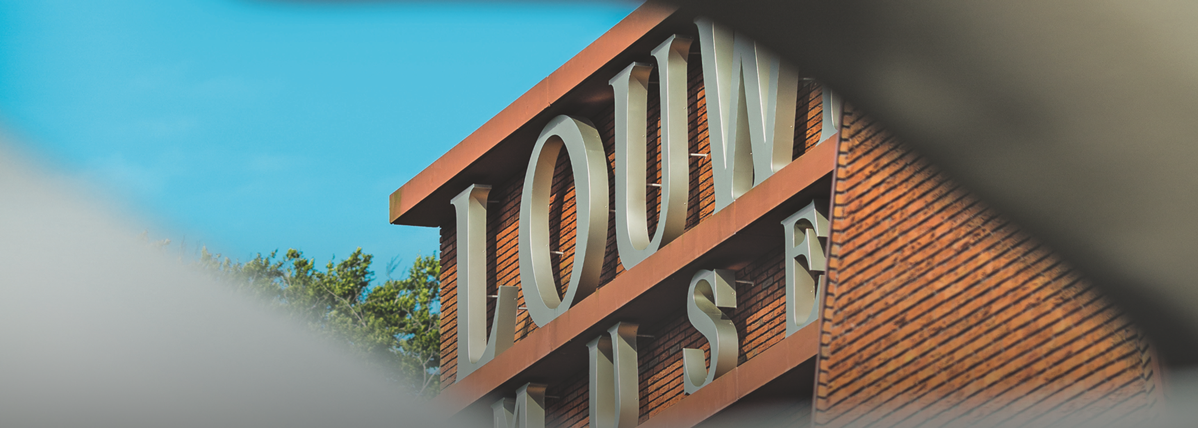Doorkijkje naar klein deel van de voorgevel met het logo van het Louwman Museum