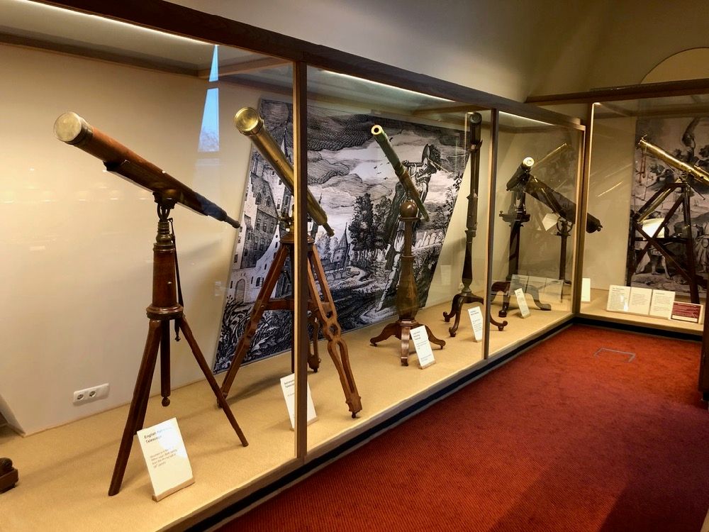 telescopen op driepoten staand in vitrine