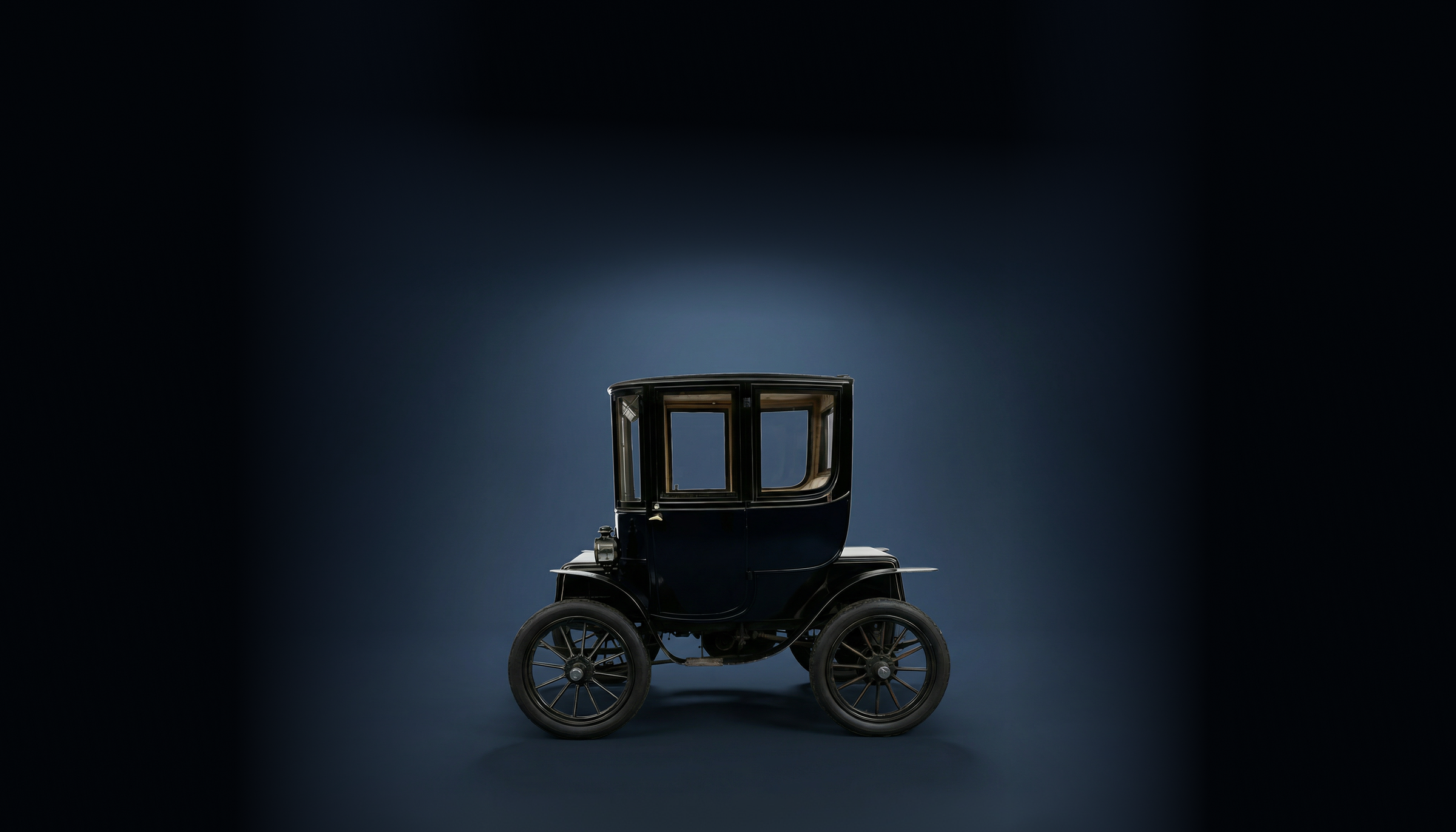 Zijaanzicht Baker Electric Coupe in donkerblauwe studio