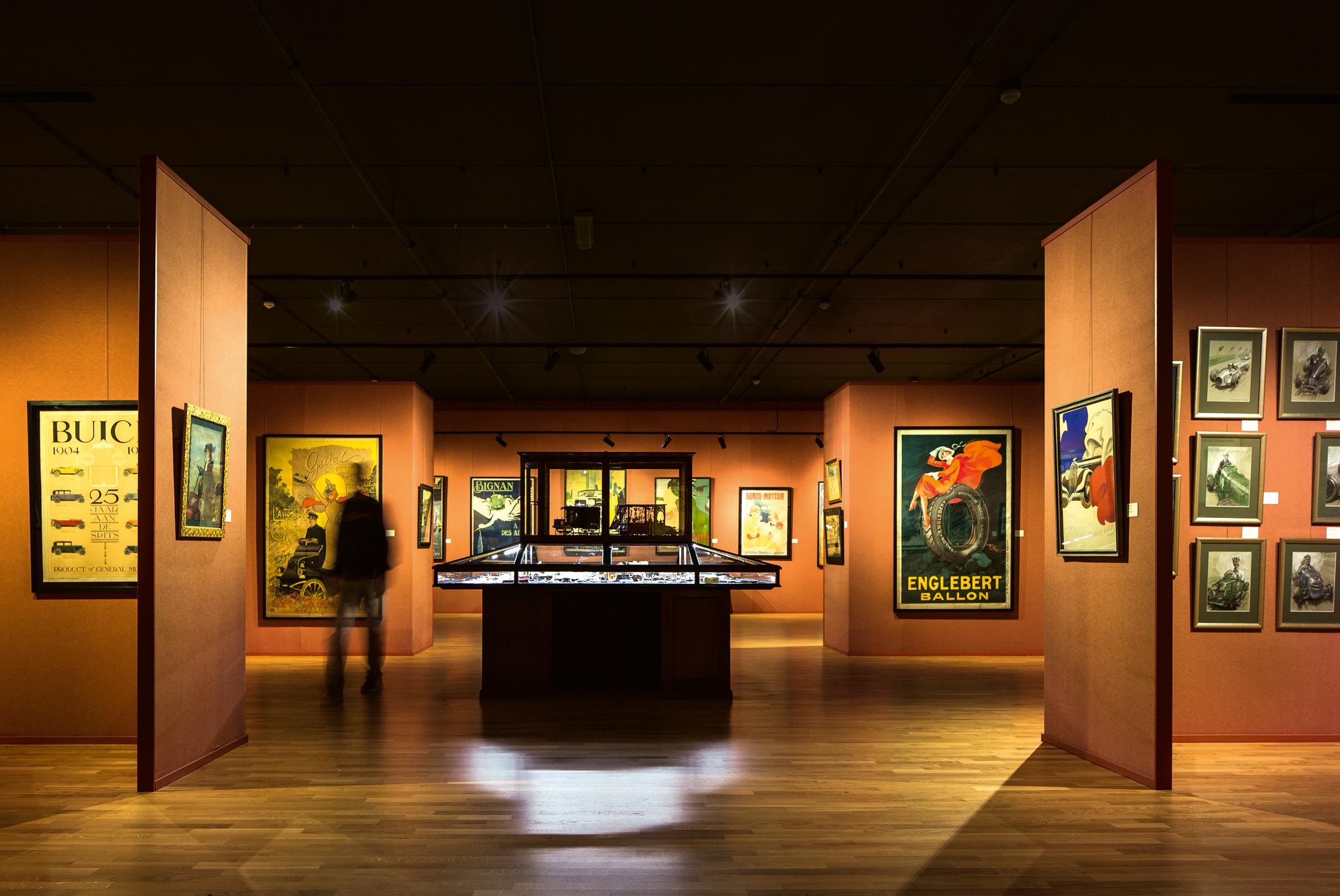Salle orange avec des oeuvres d art aux murs et une vitrine au milieu